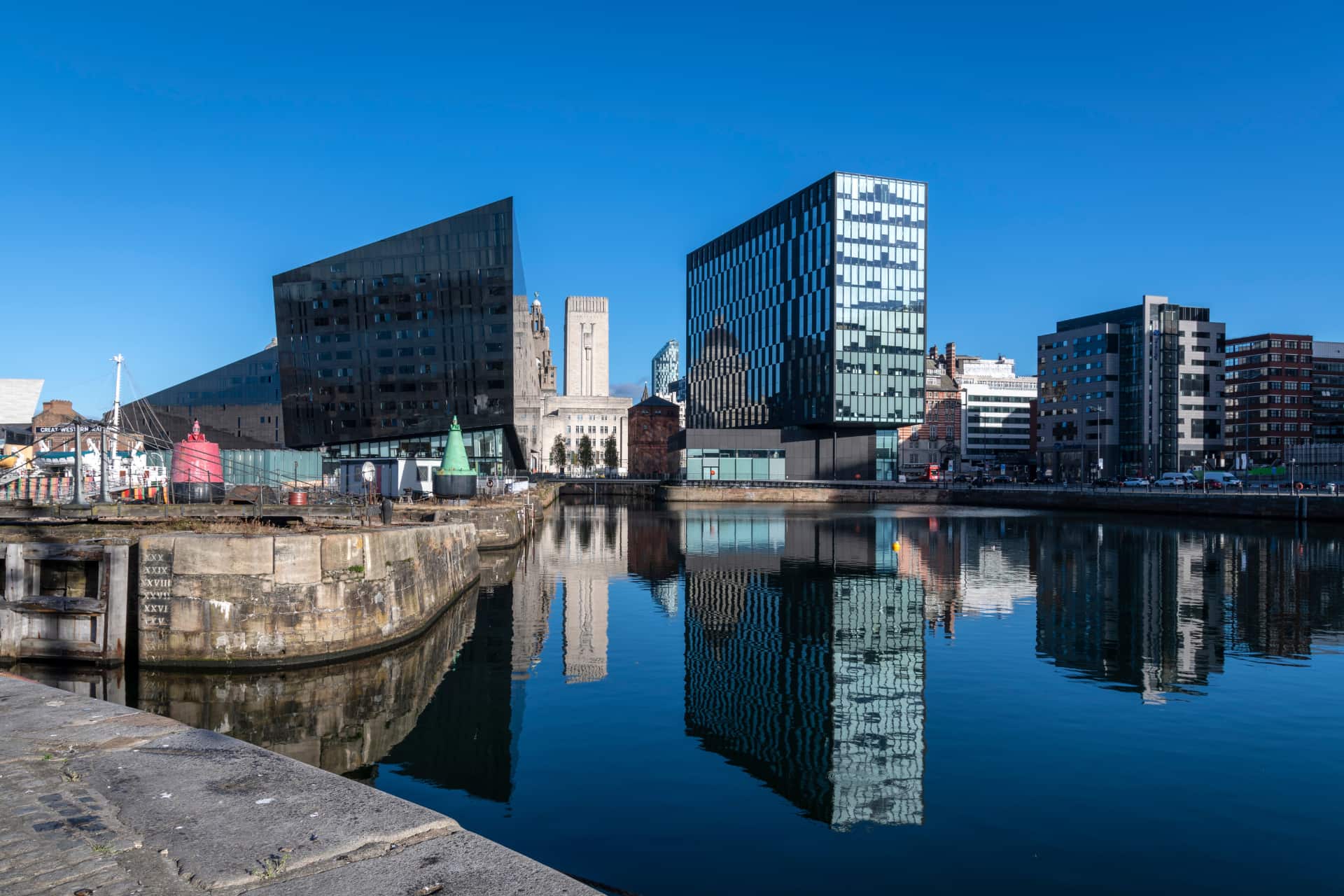 The modern buildings along the waterfront of Liverpool on a clear blue day.