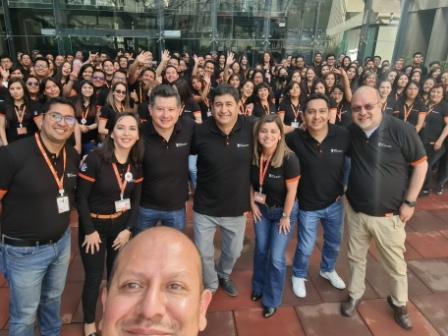 men taking selfie with large group of people behind him