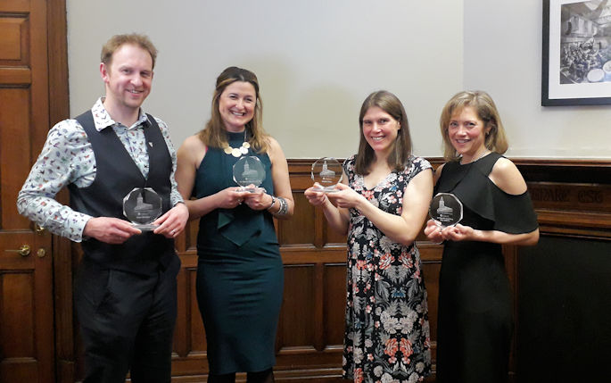 Sean, Ebony, Jasmin and Danielle holding their alumni awards and smiling