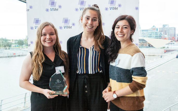Three women holding an award