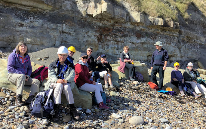 Group of 11 alumni on a beach in Scarborough