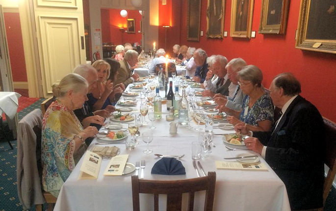 A group of people sat at a long table enjoying a meal