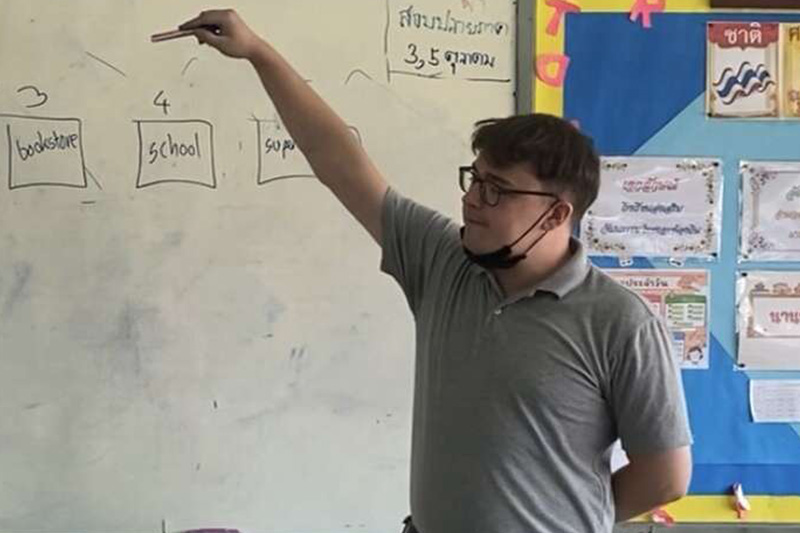 Image of someone stood in front of a board teaching a class