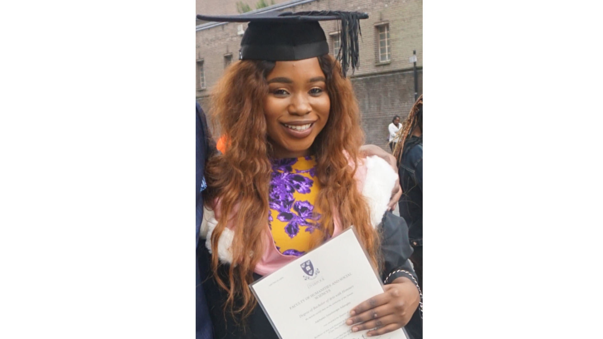 Graduate holding their certificate