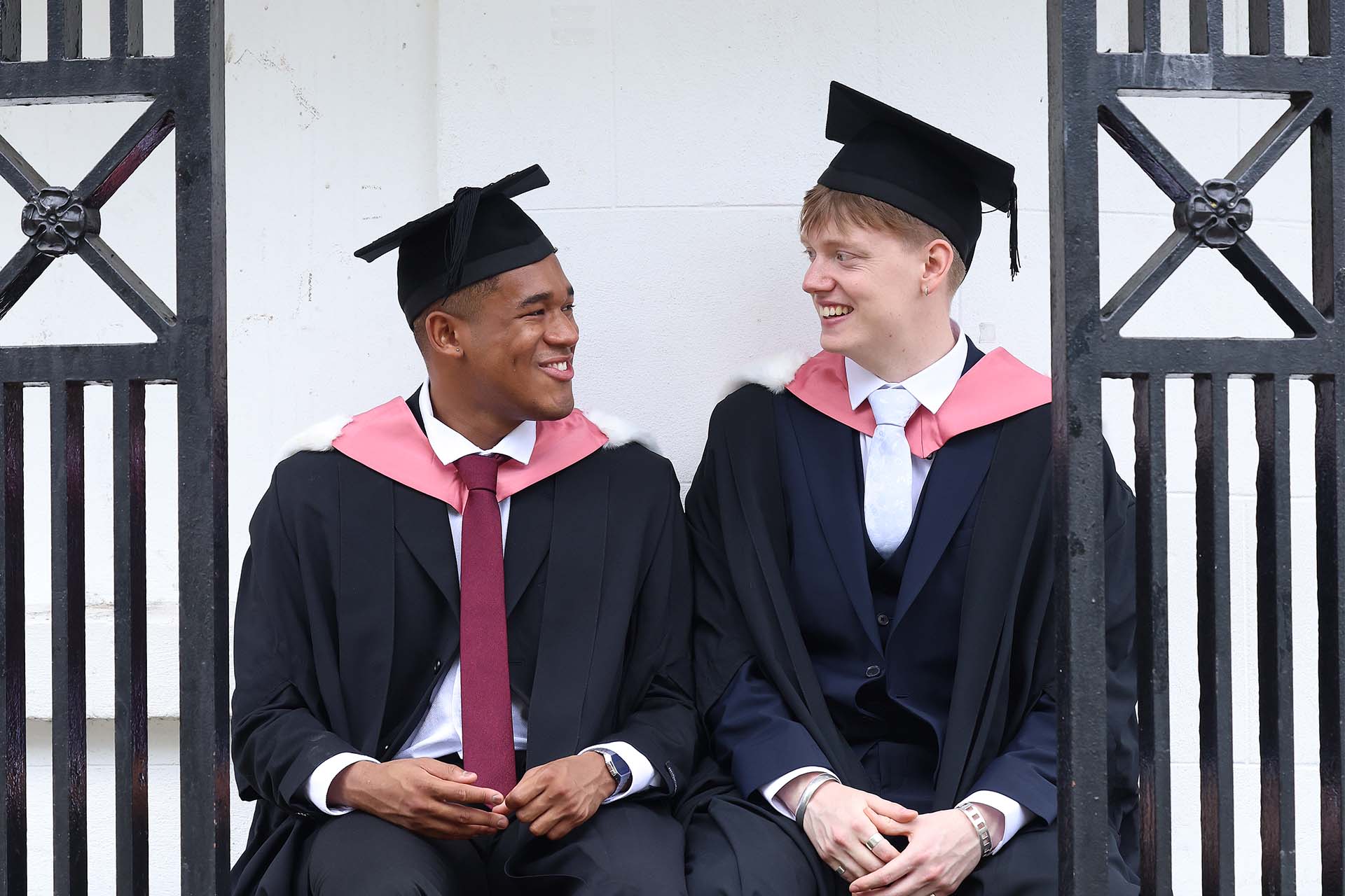 two graduates looking at one another
