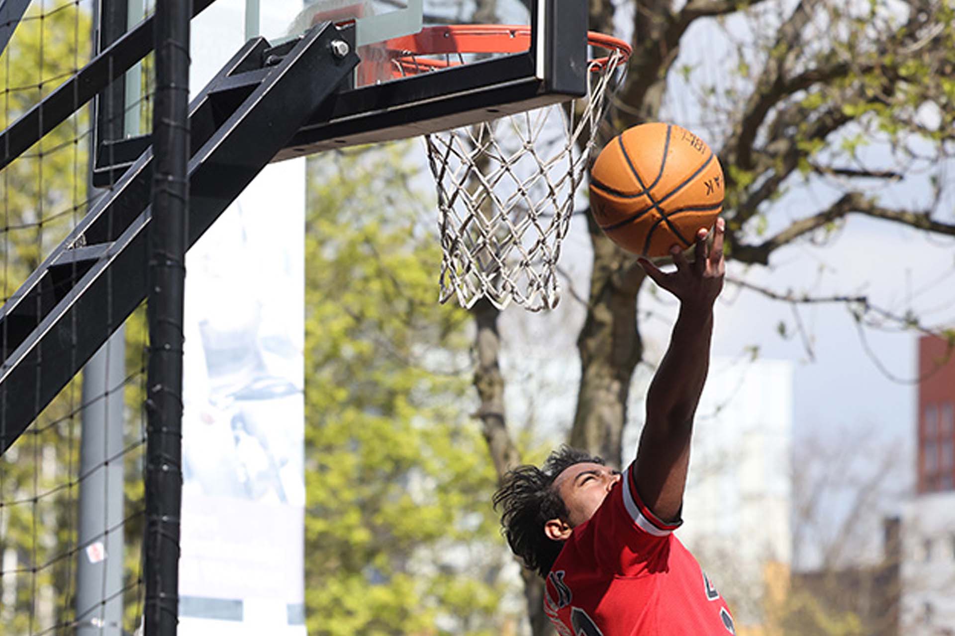 person putting a basket ball through a net