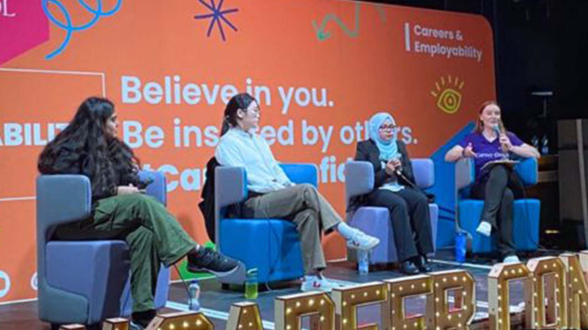 Four people sit on a panel talk