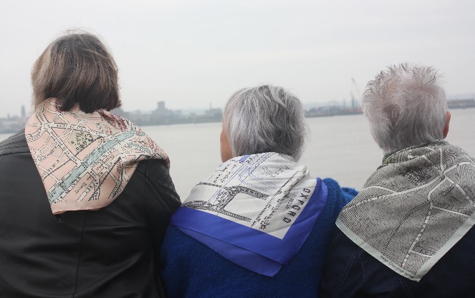 Three women look out to sea wearing Helen Chatterton scarves