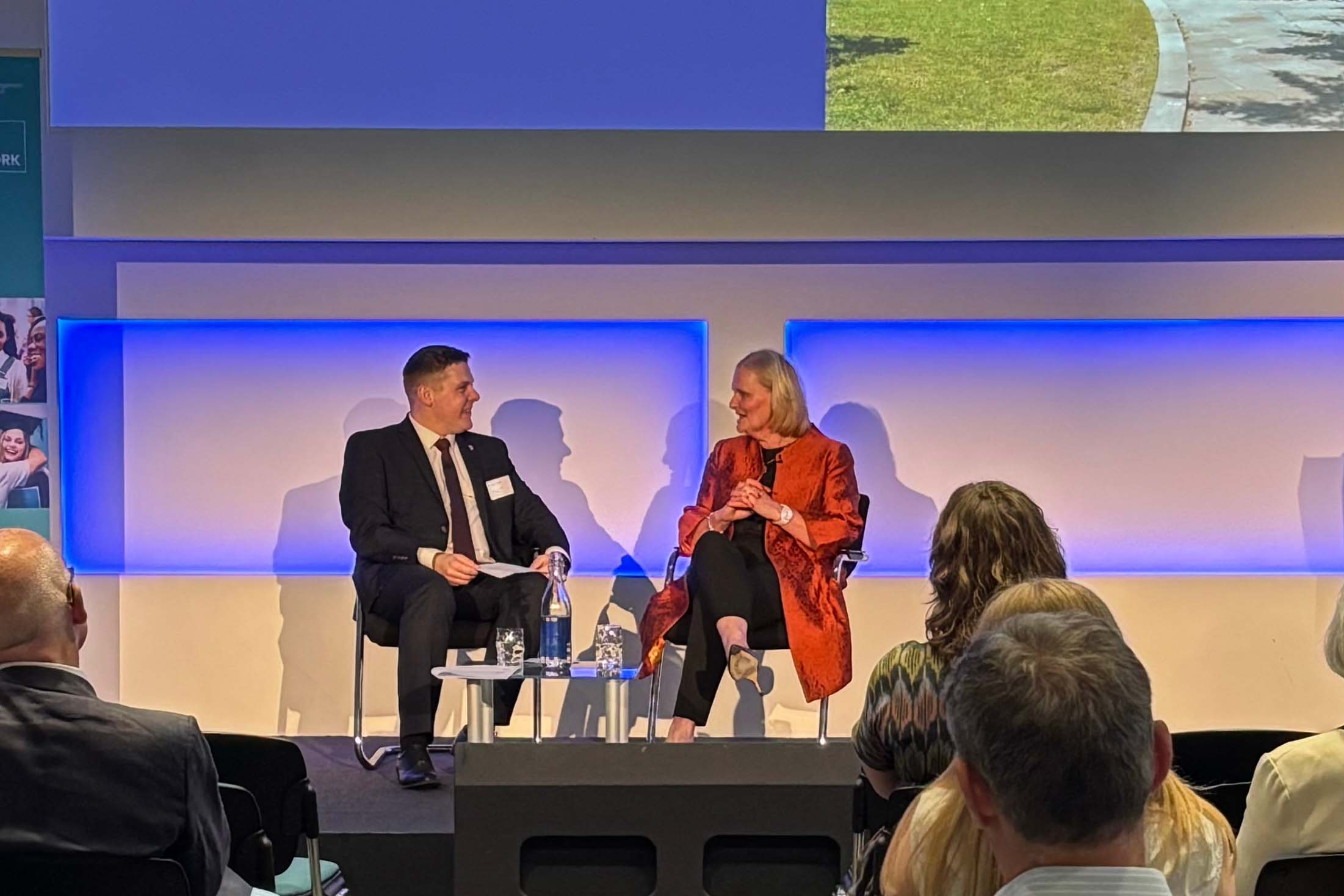 two people in conversation on stage