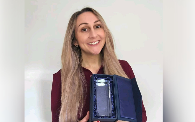 Katie smiling holding her award