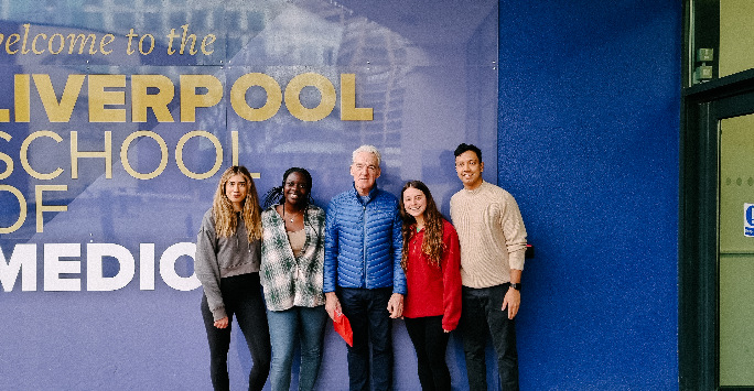 Keith and students posing outside of the Cedar House