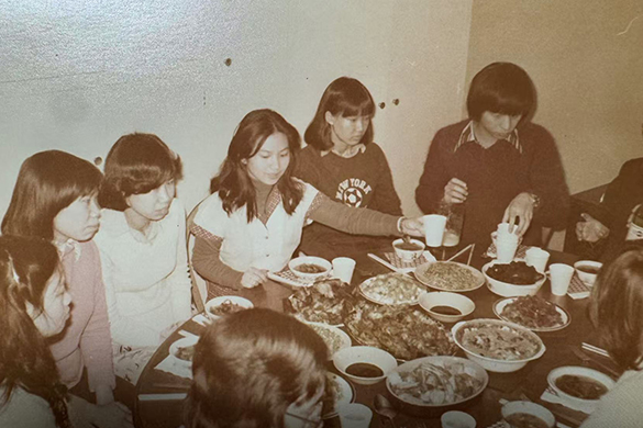 Group of University students sit down for a meal to celebrate New Year 1980