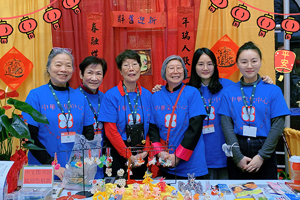 Group of people pose in front of a table filled with bedding decorations