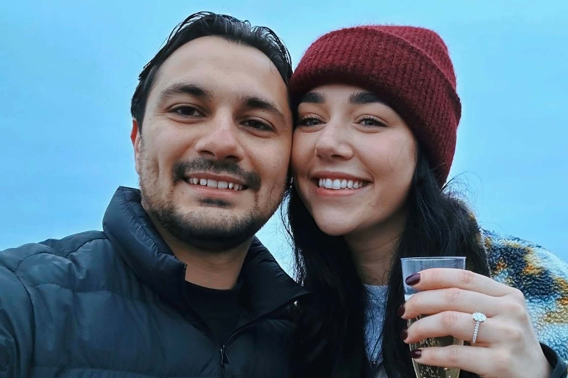 Two people with drinks celebrating their engagement