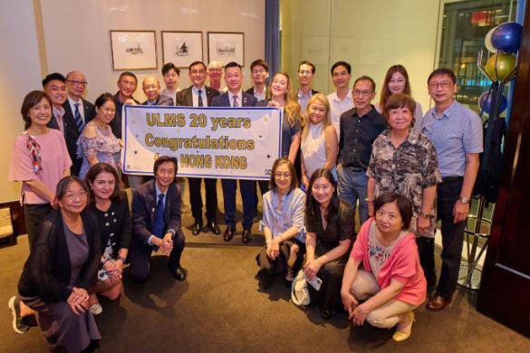 Alumni group photo holding a sign 