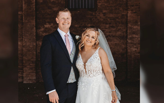 Sophie and her husband Elliott posing for a photo on the day of their wedding