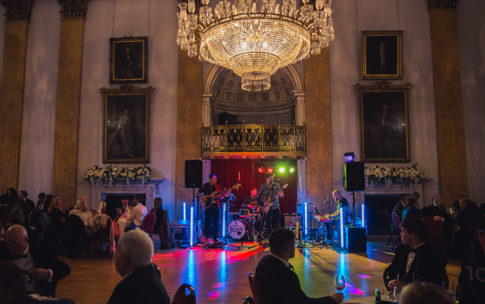 Two vet ball attendees hugging in greeting in the reception room of the Liverpool Town Hall