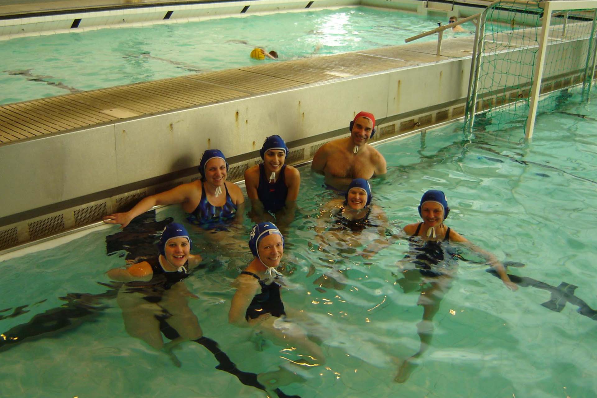 Group of people in a pool playing water polo