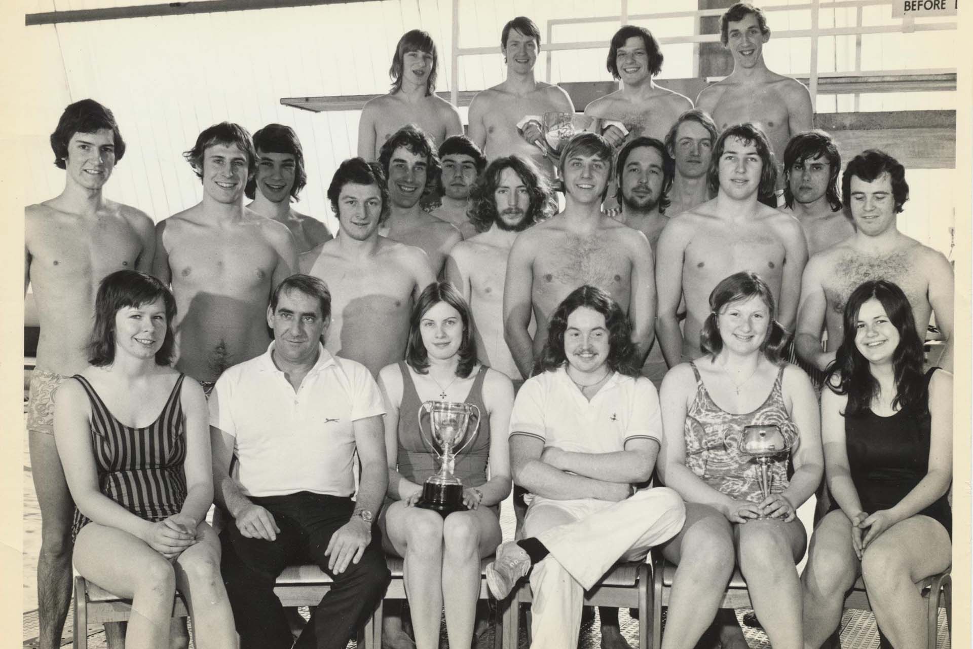 Members of a water polo team pose with a trophy