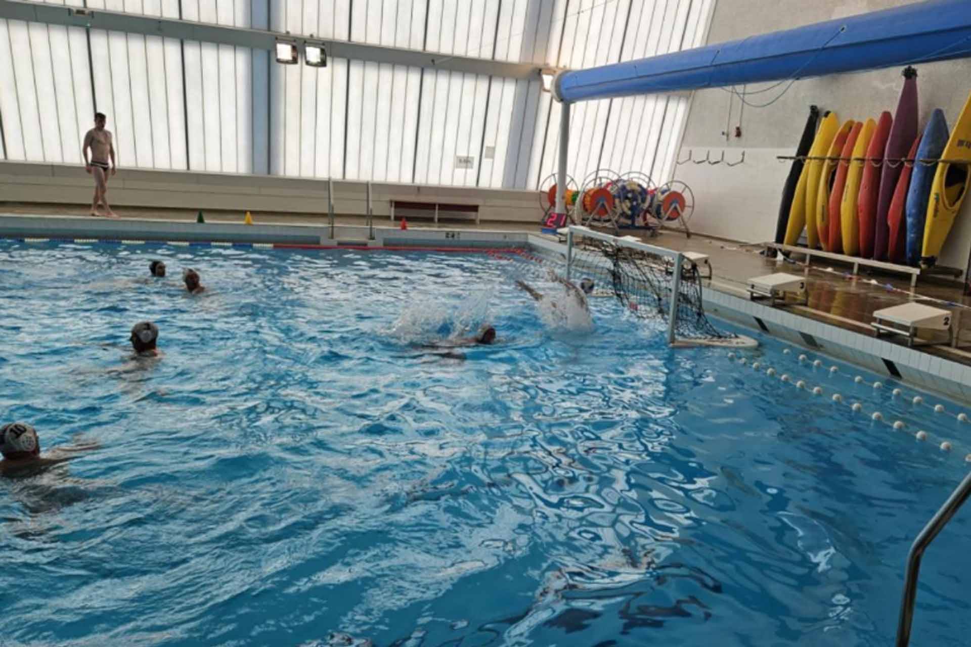 People in a pool playing waterpolo