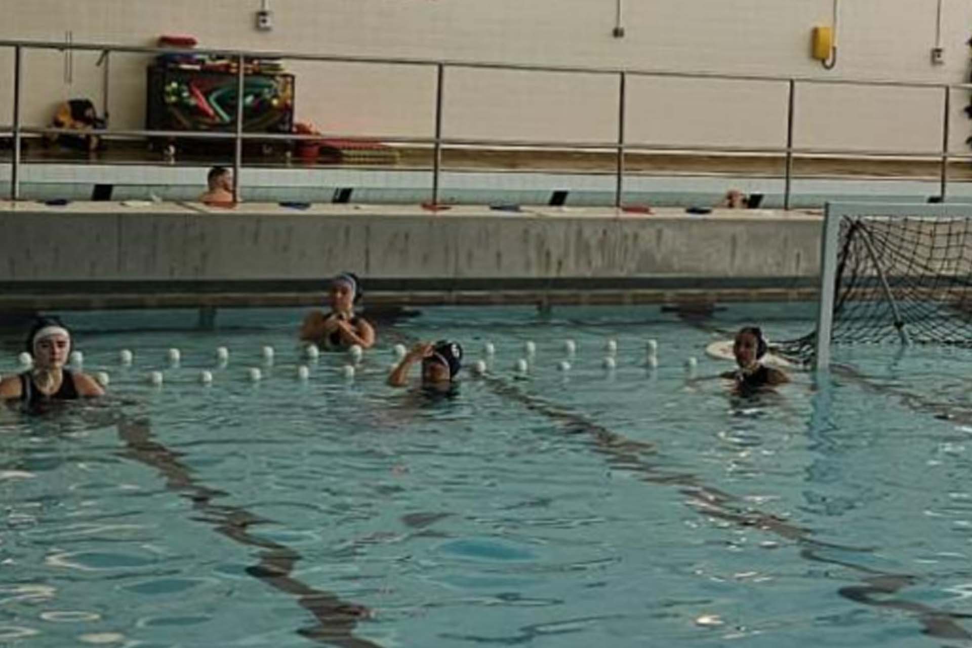 People in a pool playing waterpolo