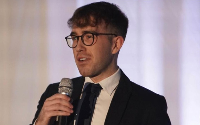 University of Liverpool graduate Anthony Polanowski with microphone in his hand.